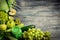 Glass jar mugs with green health smoothie, lime, apple, kiwi, grapes, avocado, lettuce on wooden background