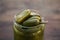 Glass jar of pickled green jalapeno peppers on wooden table, closeup