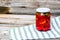 Glass jar with pickled red bell peppers.Preserved food concept, canned vegetables isolated in a rustic composition