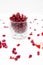 Glass jar with pomegranate seeds and scattered seeds