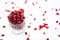 Glass jar with pomegranate seeds, sliced pomegranates and scattered seeds