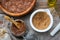 Glass jar of raw organic paste from flax seed, mortar of linseeds crushed into powder, wooden bowl of whole flax seeds and oil