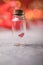 Glass jar and red heart on red background. Concept of love in Valentine`s Day