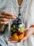 A glass jar with a salad of fruits and berries in the hands of a woman. Seasonal healthy healthy vegetarian food for a picnic