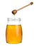 Glass jar of sunflower honey and wooden dipper isolated