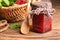 Glass jar with tasty raspberry jam on wooden table
