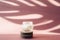 Glass jar with white moisturizing cream on wooden saw cuts on a pink background. Lotion on the background of the tropical shadow