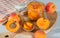 Glass jar and wooden spoon with apricot jam on a cutting board