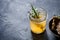 Glass jar with yellow fresh bone broth on dark gray background