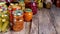 Glass jars with canned products - vegetables and fruits on an old wooden flooring.