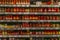 Glass jars with canned vegetables on shelves in a supermarket. A large assortment. Blurred