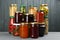 Glass jars with different pickled foods on wooden background