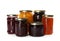 Glass jars with different pickled fruits and jams on background