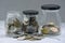 Glass jars with multicurrency coins on a table