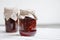 glass jars with raspberry jam on a wooden table, home-made preparations, cooking, homemade desserts