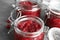 Glass jars with tasty cranberry sauce on table