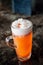 A glass of Jasmine tea orange beer cocktail with fluffy white foam and Thai Jasmine flowers