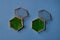 Glass jewellery boxes with greenery on blue background, top view