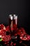 Glass of juice with a some pieces of pomegranate on a black background.