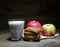 Glass of kefir, two apples and bread on a wooden background