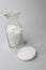 Glass laboratory jar with samples of white synthetic rubber on a white background
