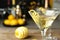 Glass of Lemon Drop Martini cocktail with zest on table against blurred background. Space for text