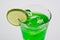 A glass of lemon green Italian soda with ice cubes isolated on white background. Homemade refreshment cold summer soft drink.