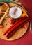 Glass of light beer, meat sausages and tomatoes on wooden board