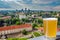 Glass of light beer with view from above of Vilnius, Lithuania.  Areal view of Vilnius, red rooftops, river, skyscrapers in