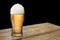 Glass of light beer on wooden table