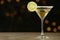 Glass of Lime Drop Martini cocktail on grey table against blurred background
