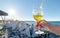 Glass with limonade in hand  on the beach in sea port blue sky  sun beam reflection and  scene