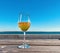 glass with limonade wooden table  on the beach in sea port blue sky  sun beam reflection and  scene