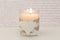 Glass with lit vanilla candle and white heart