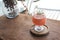 A glass of litchi fruit juice on wooden saucer and table in cafe