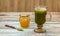 Glass of macha green tea with green tea powder in a spoon and small bottle of honey