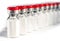 Glass medical vials of biotech drugs. With red caps.