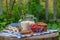 Glass of milk and bowl of fresh berries in an outdoor setting