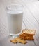 glass of milk and cracker on white wood