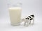 Glass of milk with dairy cow. Milk cow. Black and white cow with spots. Spotted cow. Ruminant farm animal. Drink. Milk. Toy cow. I