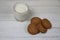 A glass of milk and a pile of cookies on wooden table flat lay