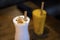 A glass of milk shake and mango smoothie with wooden straw for environmet friendly