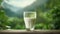 Glass of milk on wooden table with green grass background, closeup. Glass of milk on wooden table with nature background.