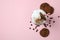 Glass of milkshake, coffee seeds and cookies on pink background