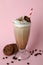 Glass of milkshake, coffee seeds and cookies on pink background