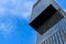 Glass modern skyscraper with blue sky background. Low angle view and architecture details. Windows of glass office building.