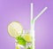 Glass of mojito cocktail on pastel pink background