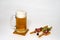 Glass mug with beer on white background. Breadsticks wrapped in ham with olives and a sprig of parsley