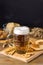 Glass Mug of Tasty Light Beer and Snacks on Wooden Table Pretzel Cracker with Solt Vertical