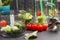 Glass mugs with broccoli, tomato and green straws. Metal chopper Chard leaves  tomato on table